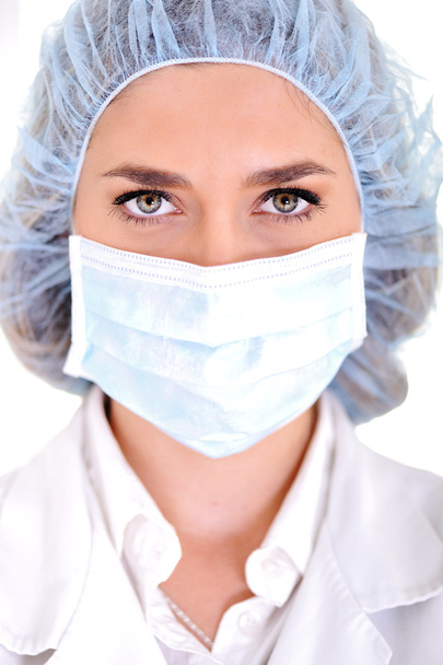 Female doctor wearing surgical cap and mask - Foto, Imagen