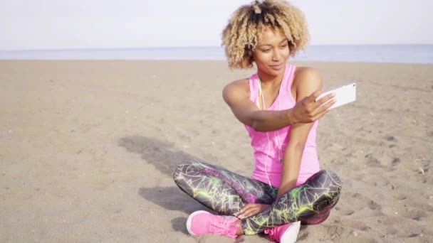 žena seděla na písku a přijetí selfie - Záběry, video