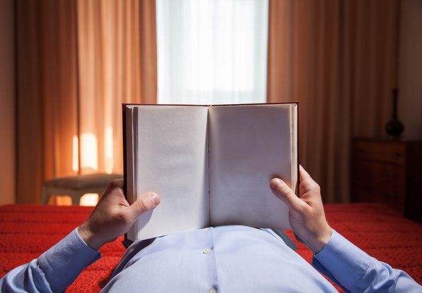 Man holding opened book at home - Photo, image