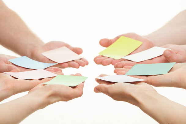 Human hands reaching out colorful paper cards - Foto, afbeelding