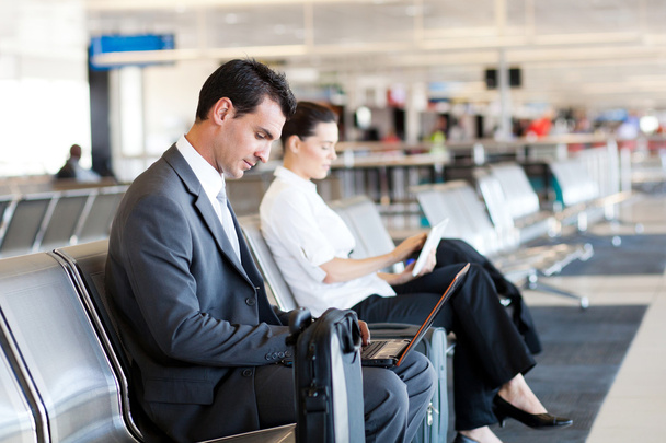 Businessman and businesswoman using computer at airport - Foto, Imagen