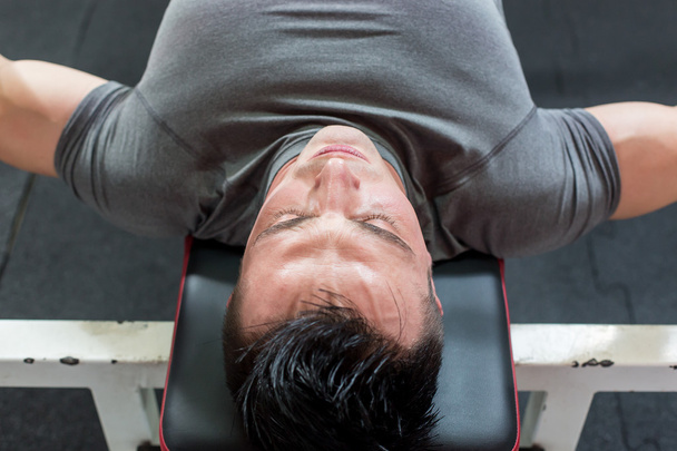 Young Man In Gym Exercising Chest On The Bench Press - top view - Φωτογραφία, εικόνα