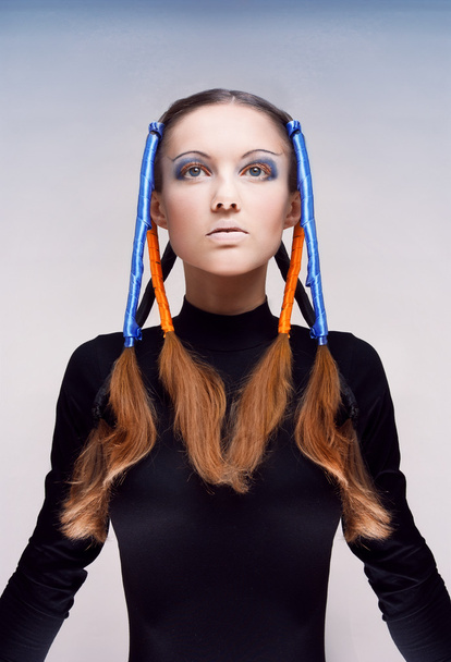 Студийный портрет молодой женщины с голубыми и оранжевыми лентами в волосах
 - Фото, изображение