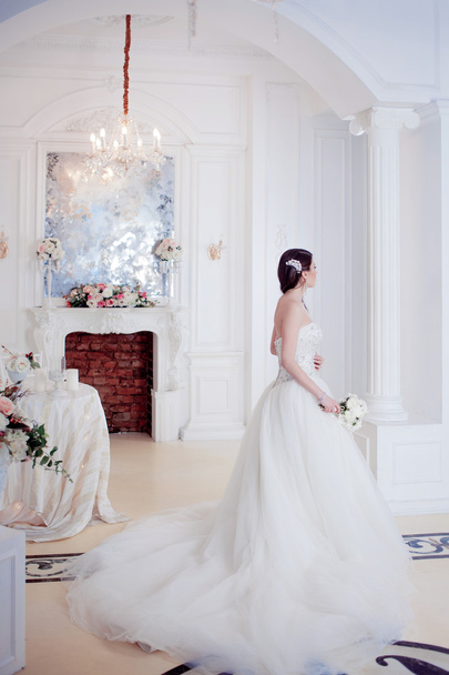 Portrait of beautiful bride. Wedding dress with open back. Luxurious light interior - Φωτογραφία, εικόνα