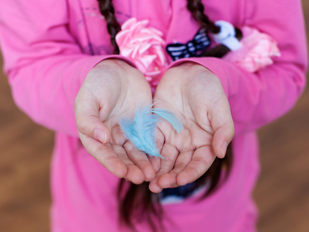 girl's hands keeping a feather - Φωτογραφία, εικόνα