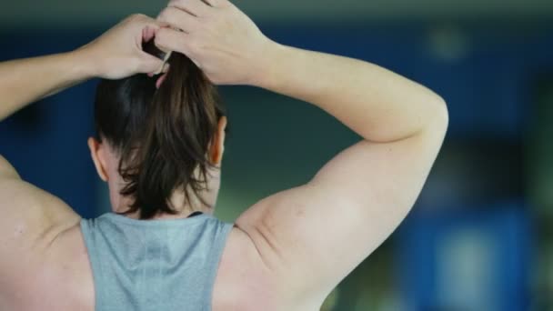 woman tying back her hair - Filmagem, Vídeo