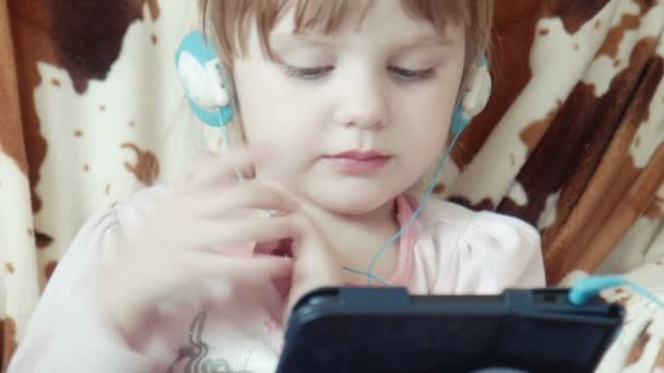 小さなかわいい女の子は、デジタル タブレット上のビデオを見る - 映像、動画