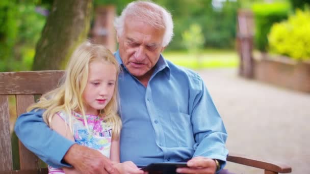 Großvater und Enkelin schauen auf Computer-Tablet - Filmmaterial, Video
