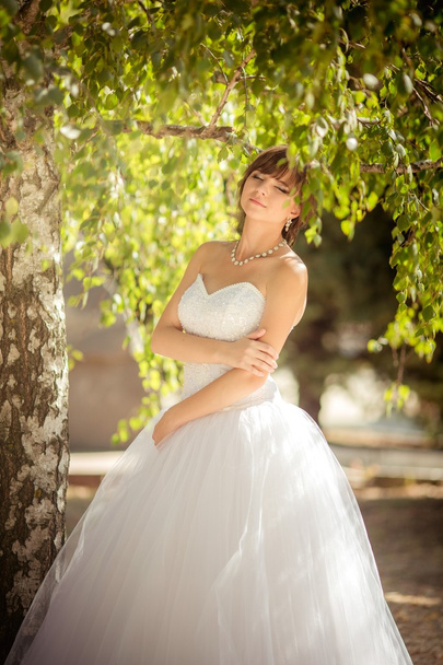 Beautiful bride in green park - Fotó, kép