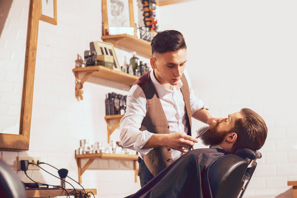 barber cutting beard of handsome man - Φωτογραφία, εικόνα