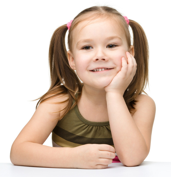 Szczęśliwa dziewczynka siedzi przy stole i uśmiech - Zdjęcie, obraz