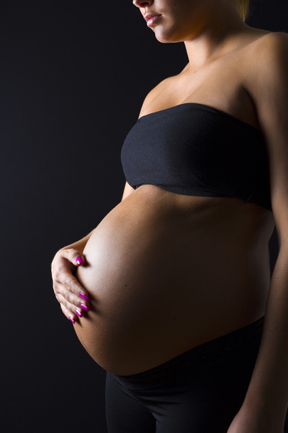 Kobieta w ciąży z jej ręki na goły brzuch - Zdjęcie, obraz