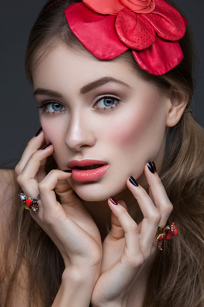 Hermosa chica con flor roja en la cabeza
 - Foto, Imagen
