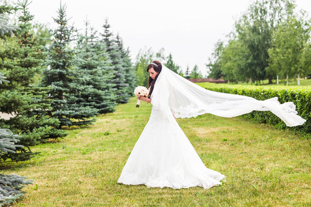 Beautiful bride with bouquet of flowers outdoor - Foto, Imagem