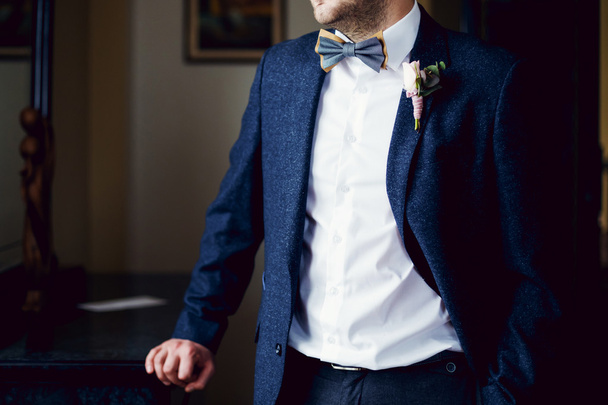 The groom looks out of the window, has put a hand in a pocket - Fotoğraf, Görsel