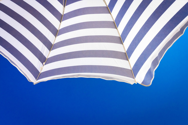 High resolution beach umbrella on blue sky background - Photo, image