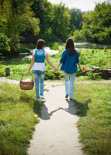 Two girls walking hand in hand - Фото, зображення