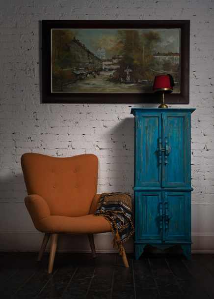 Vintage orangefarbener Sessel, blauer Schrank, Hängemalerei und Blac - Foto, Bild