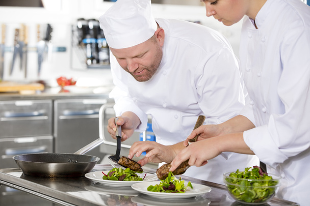 Biefstuk schotel in restaurant glimlachen van professionele chef-kok bereiden - Foto, afbeelding