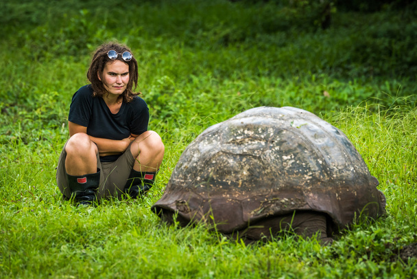 Woman staring intently at Galapagos giant tortoise - Photo, Image