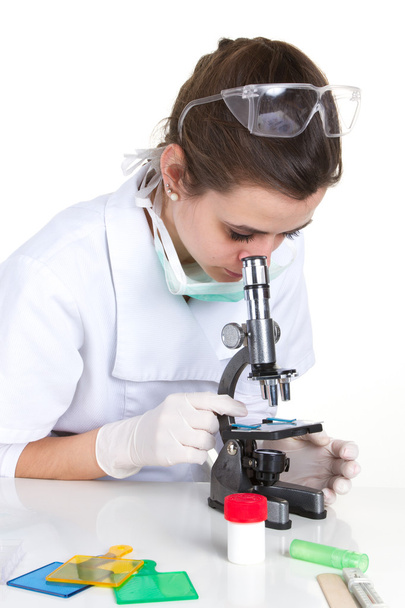 Atractivo morenascientista mirando a través de un microscopio en un laboratorio
 - Foto, imagen