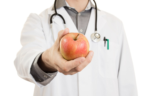 Питательный врач, давая яблоко, изолирован
 - Фото, изображение