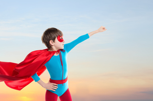 Superhero kid flying on sunset sky. - Фото, зображення