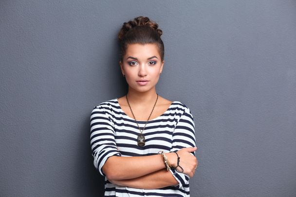 Young woman standing, isolated on gray background - Photo, Image