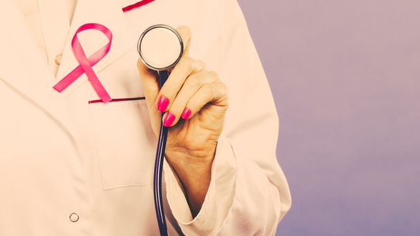 Cinta rosa con estetoscopio en uniforme médico
. - Foto, imagen
