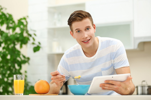 man with tablet and having breakfast - Zdjęcie, obraz