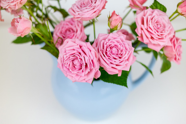 Pink flowers in blue jug.  - Photo, Image