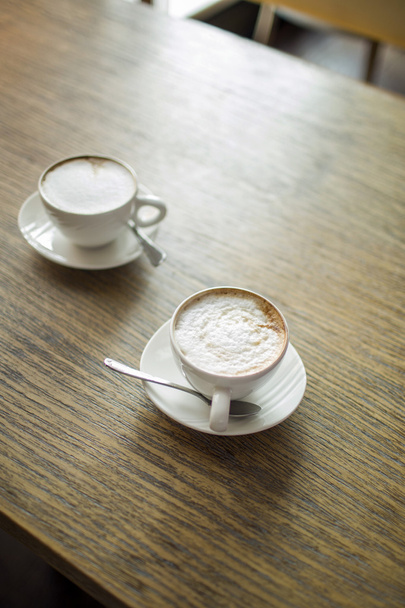 two cups of coffee on wooden table - Foto, imagen
