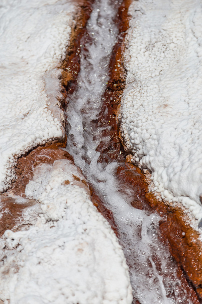 Water lopen tussen zout kristal deposito's in verdamping vijvers op Maras, Peru - Foto, afbeelding