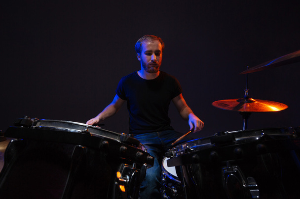 Attractive concentrated bearded man drummer playing his kit  - Фото, зображення