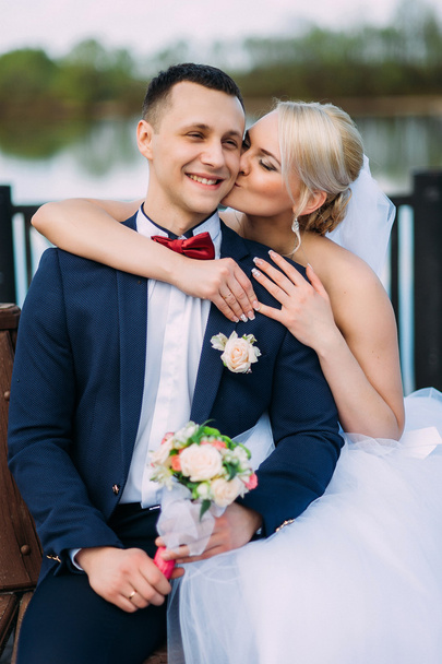 Nevěsta políbila tvář ženicha na svatební den v objetí venku o - Fotografie, Obrázek
