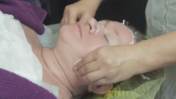 Cosmetoloog veeg gezicht van vrouw in Beauty Saloon door katoen pad na algen masker - Video