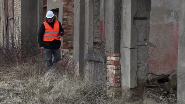 Engineer with tablet PC near to the abandoned, destroyed buildings - Záběry, video