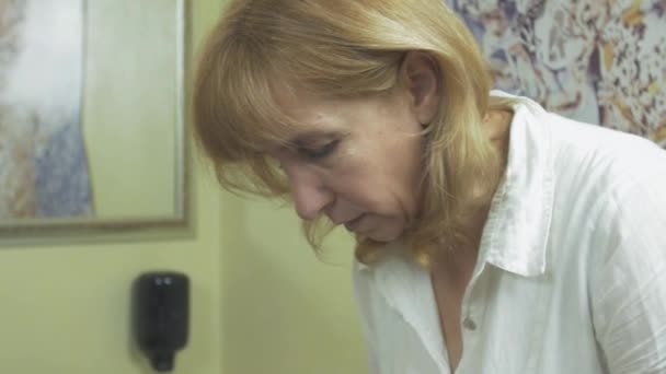 Il cosmetologo di faccia asciuga la faccia di donna in salone da cuscinetto di cottone dopo maschera di alghe
 - Filmati, video