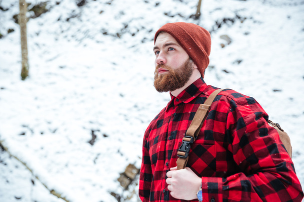 Bearded man with backpack in winter mountain forest - Foto, Imagen