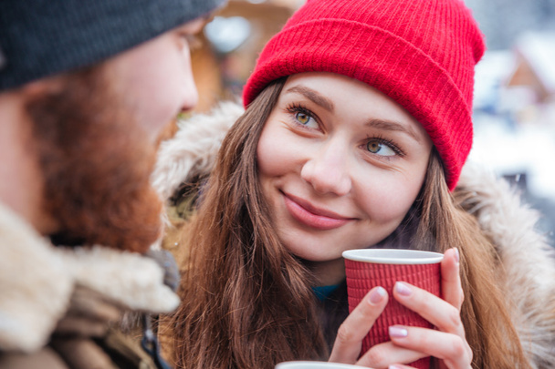 Couple drinking hot coffee outdoors in winter - Foto, afbeelding
