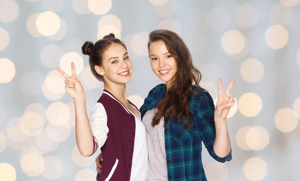 happy teenage girls hugging and showing peace sign - Fotografie, Obrázek