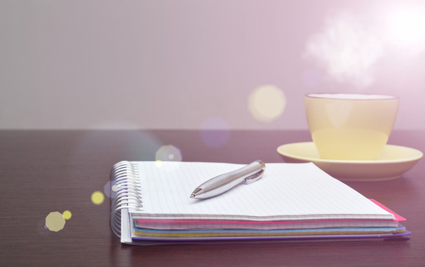 Notebook, stalen pen en geel op de tafel met zonlicht - Foto, afbeelding