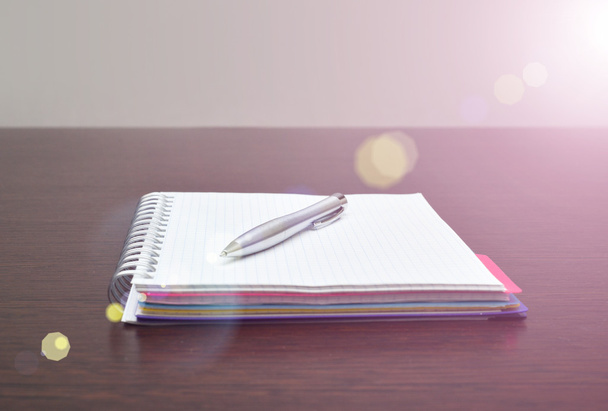 Notebook en stalen pen op de tabel met zonlicht - Foto, afbeelding