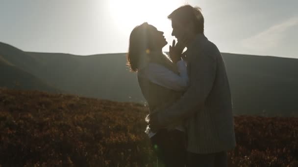couple in warm clothing embracing in meadow - Footage, Video