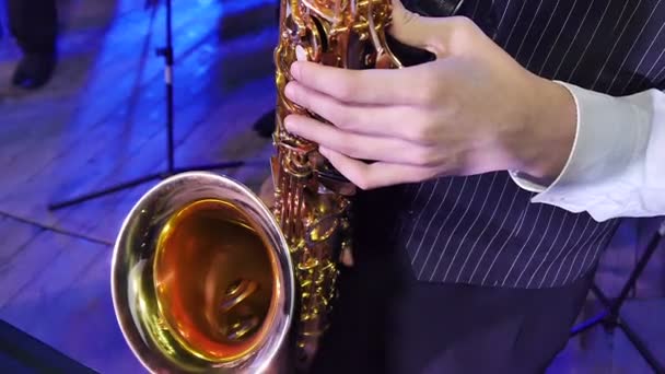 Primer plano de los dedos presionando las teclas del saxofón
 - Metraje, vídeo