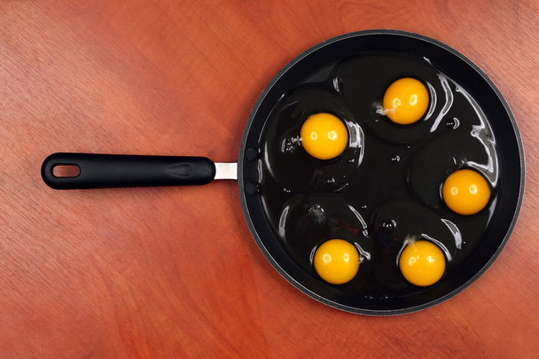 п'ять курячих яєць на сковороді перед приготуванням
 - Фото, зображення