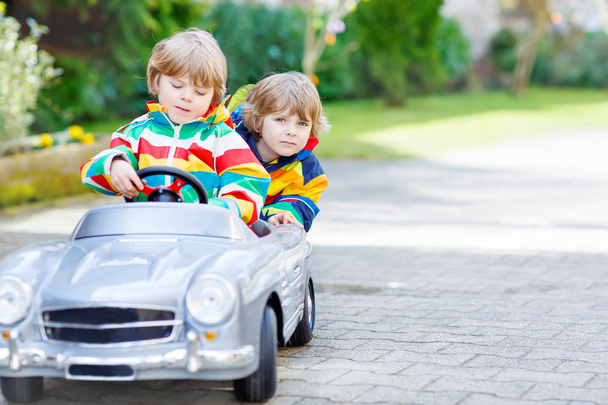 Két boldog testvér fiú játék-val nagy régi játék-autó - Fotó, kép