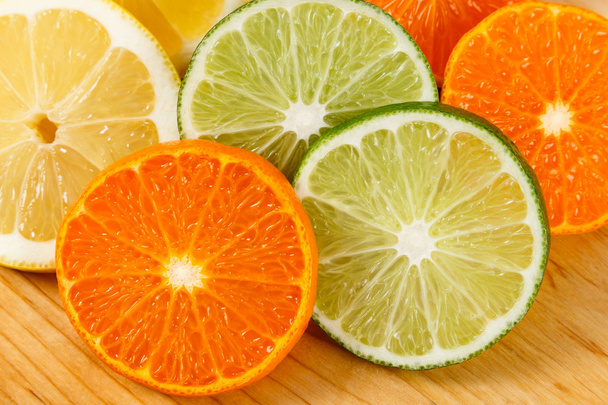 gesneden citrusvruchten, limoenen, citroenen en sinaasappels - Foto, afbeelding