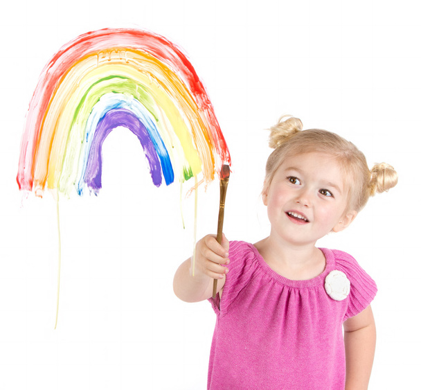 Little girl paints rainbow on window - Foto, afbeelding