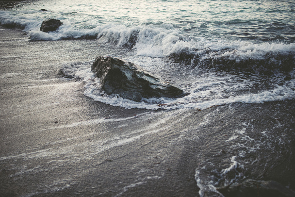 Detail of the shore of the beach with sand, rock and waves - Photo, image